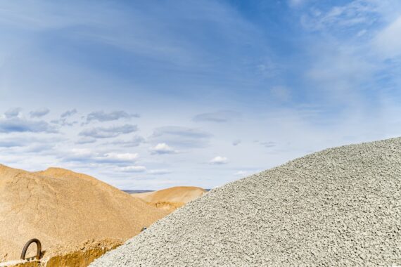 Materials for asphalt hot mix plant - sand and stones, clear blue sky, copy space. The photo is taken in asphalt factory near Sofia, Bulgaria with Sony A7III camera.